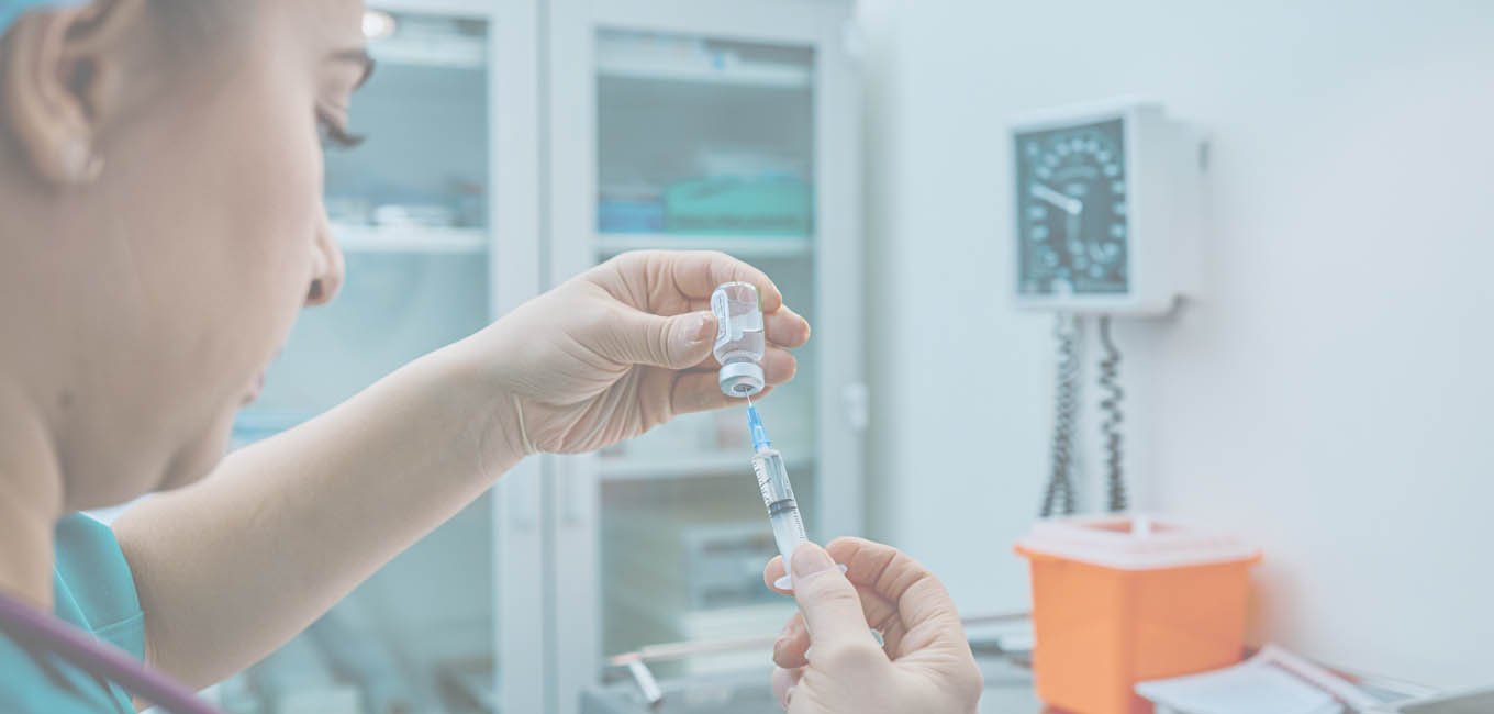 Девушка в стерильной одежде наполняет шприц